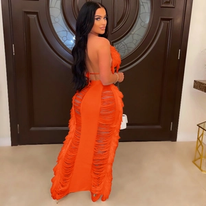 Detail of vibrant orange knitted beach set featuring a backless halter top and fringe skirt