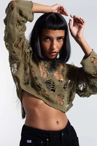 Close-up of army green cropped knit sweater featuring irregular hollow-out distressed details
