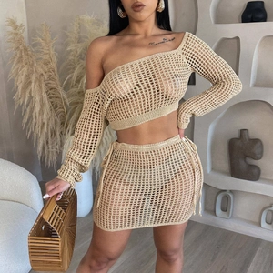 Detail of crochet knit texture on beige one-shoulder top and drawstring mini skirt