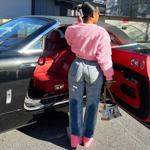 Chic pink faux fur crop jacket paired with high waist jeans in a luxury street setting