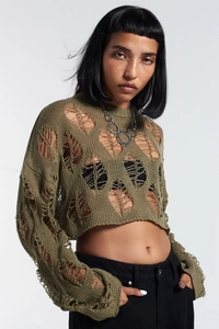 Close-up of olive green distressed knit crop top with aesthetic cutout details