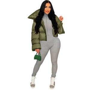 Detail showing an olive green quilted puffer jacket paired with a grey bodysuit and green bag