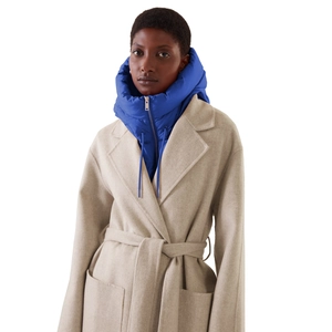 Détail d'un manteau en laine avoine avec cache-cou à capuche en duvet bleu vif
