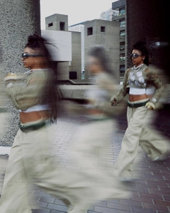 Artistic motion blur shot of sage green cropped knit sweater with distressed cutouts