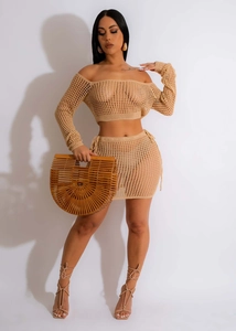 Detail of crochet knit two-piece set featuring hollow mesh texture and drawstring skirt