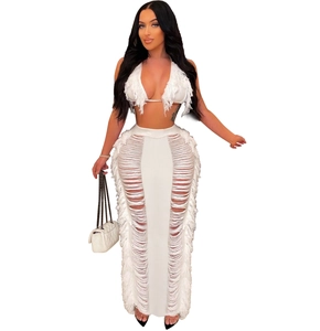 Detail of white two-piece knit beach set with V-neck fringe crop top and cutout maxi skirt