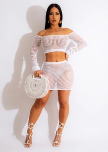 Detail of white crochet two-piece set featuring hollow knit texture and off-shoulder long sleeves