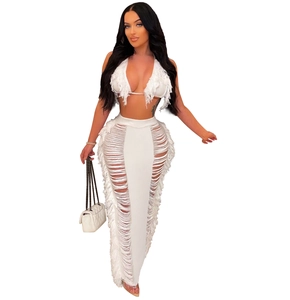 Detail of white two-piece set featuring tassel halter top and side cutout maxi skirt