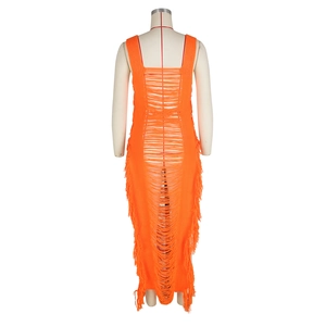 Détail d'une robe de plage orange vif en maille ajourée avec des pompons et des franges