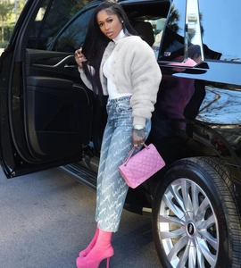 Chic light gray faux fur jacket paired with blue denim jeans and vibrant pink sock boots
