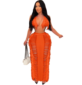 Detailed view of the vibrant orange knit set featuring deep V-neck and tiered fringe accents