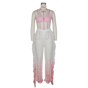 Detail of pink halter bikini top and white ombre fringe knit trousers for beach vacation