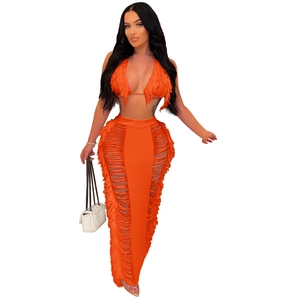 Close-up of orange crochet knit two-piece beach set featuring long bohemian tassels