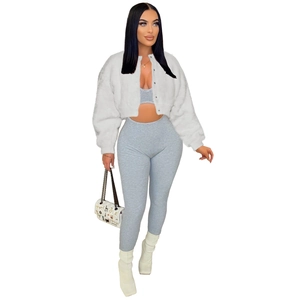 Detail of white faux fur cropped jacket paired with grey knit top and matching pants