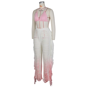 Detail of pink gradient knit pants featuring side fringe and distressed cutout textures