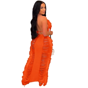 Detail view of bright orange halter backless dress with layered tassel and fringe texture