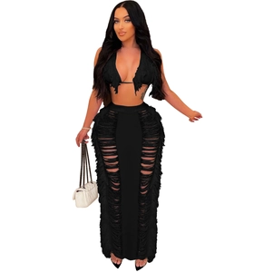 Detail of black knit beach set showing fringe hem and cut-out texture on the skirt