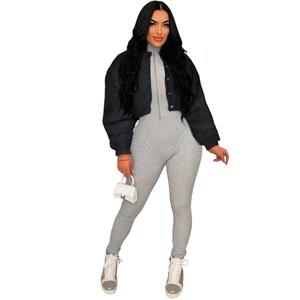 Detail view of a black faux fur short jacket paired with a grey ribbed bodysuit and white bag