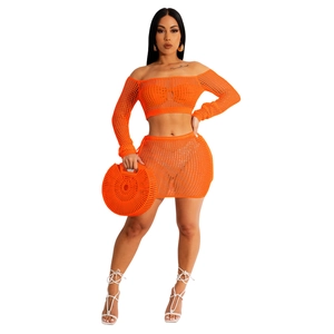 Detail of orange crochet two-piece beach set featuring hollow knit pattern and mini skirt