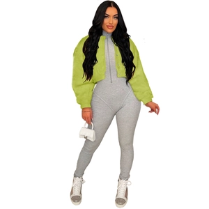 Neon green faux fur jacket paired with a gray bodysuit and white hourglass handbag
