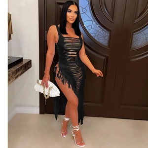 Détail de la robe en maille noire ajourée avec découpes sexy et longues franges latérales