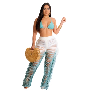 Detail of gradient blue crochet pants with handmade tassels and boho knit hollow pattern