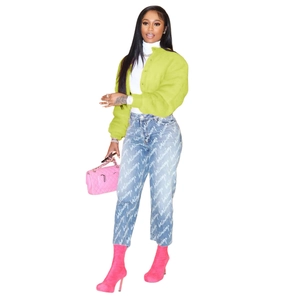 Detail of neon green cropped faux fur jacket with luxury print jeans and pink boots