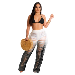 Detail of high-waisted crochet hollow-out pants with gradient fringe and tassel knit texture