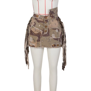 Detail of camouflage mini skirt with fringe decor and button closure on white mannequin