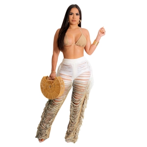 Detail of bohemian knit beach set featuring cutout tassel trousers and a halter neck top