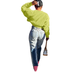 Back view of a neon green faux fur short jacket and light blue washed denim jeans