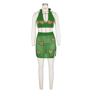 Dettaglio del set due pezzi in maglia verde con motivi a cuore colorati e trama all'uncinetto