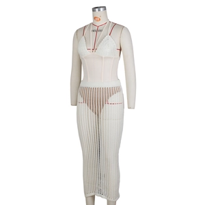 Dettaglio di un set all'uncinetto bianco a due pezzi con corsetto e gonna lunga traforata