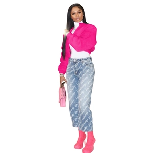 Detail of trendy rose red faux fur jacket paired with high waist logo printed blue jeans