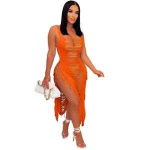 Détail de la robe en maille ajourée orange avec de longues franges et une fente latérale haute