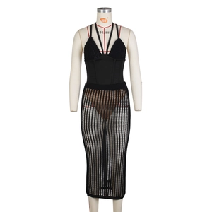 Dettaglio del set con top nero all'uncinetto e gonna lunga in maglia a rete