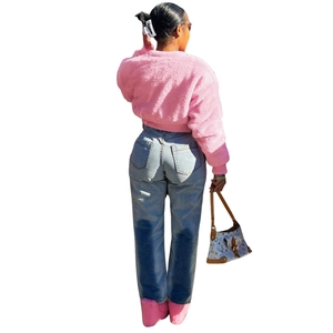 Rear view of a fuzzy pink faux fur jacket paired with gradient blue denim jeans