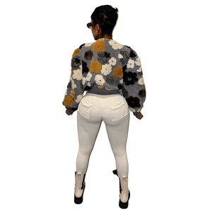 Detail view of a cropped fleece jacket featuring large yellow and black floral patterns