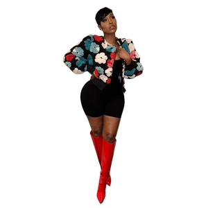 Detailed close-up of vintage black cardigan with 3D colorful floral textures and red boots