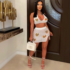 Dettaglio del set in maglia bianca con cuori arcobaleno e top corto con scollo a cavezza