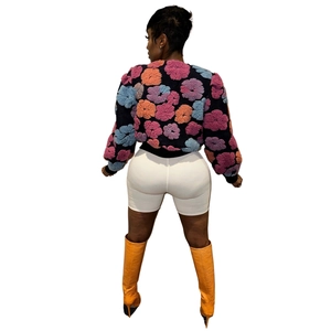 Rear view of floral knit cardigan paired with orange crocodile boots for chic style