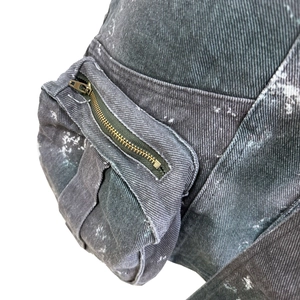 Détail macro de la texture denim délavé avec effet de peinture et fermeture en laiton