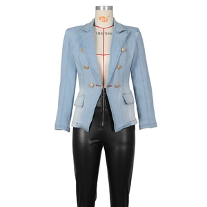 Detailed view of light blue denim blazer with golden embossed lion buttons and flap pockets