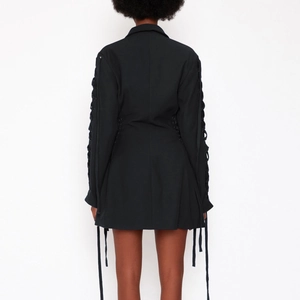 Detailansicht der Schnürung an Rücken und Ärmeln dieses schwarzen Blazer-Kleides