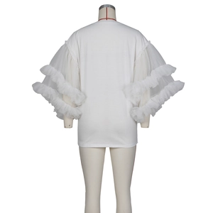 Detailed close-up of white t-shirt showing tiered mesh ruffle sleeves on a mannequin