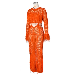 Detail of bright orange crochet beach dress featuring mesh knit and feather fringe trim
