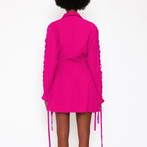 Detailansicht des fuchsiafarbenen Blazer-Kleides mit Schnürung an den Ärmeln und Taillenband
