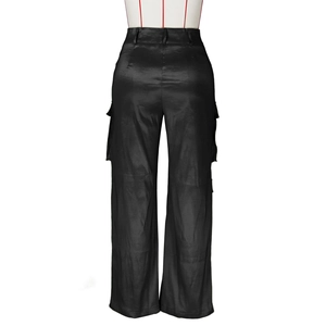 Détail du pantalon cargo en satin noir montrant le tissu brillant et les grandes poches