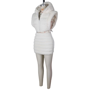 Dettaglio del gilet con cappuccio in finta pelliccia trapuntata e gonna bianca