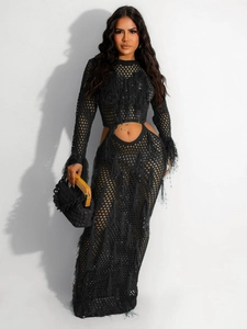 Detail of black mesh crochet dress showing hollow-out knit texture and fringe tassels